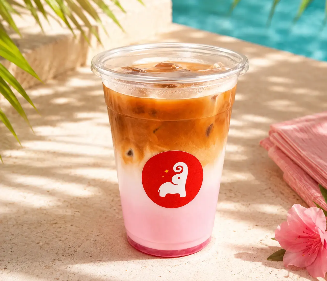 Tai Sweets iced coffee layered over milk in a branded cup