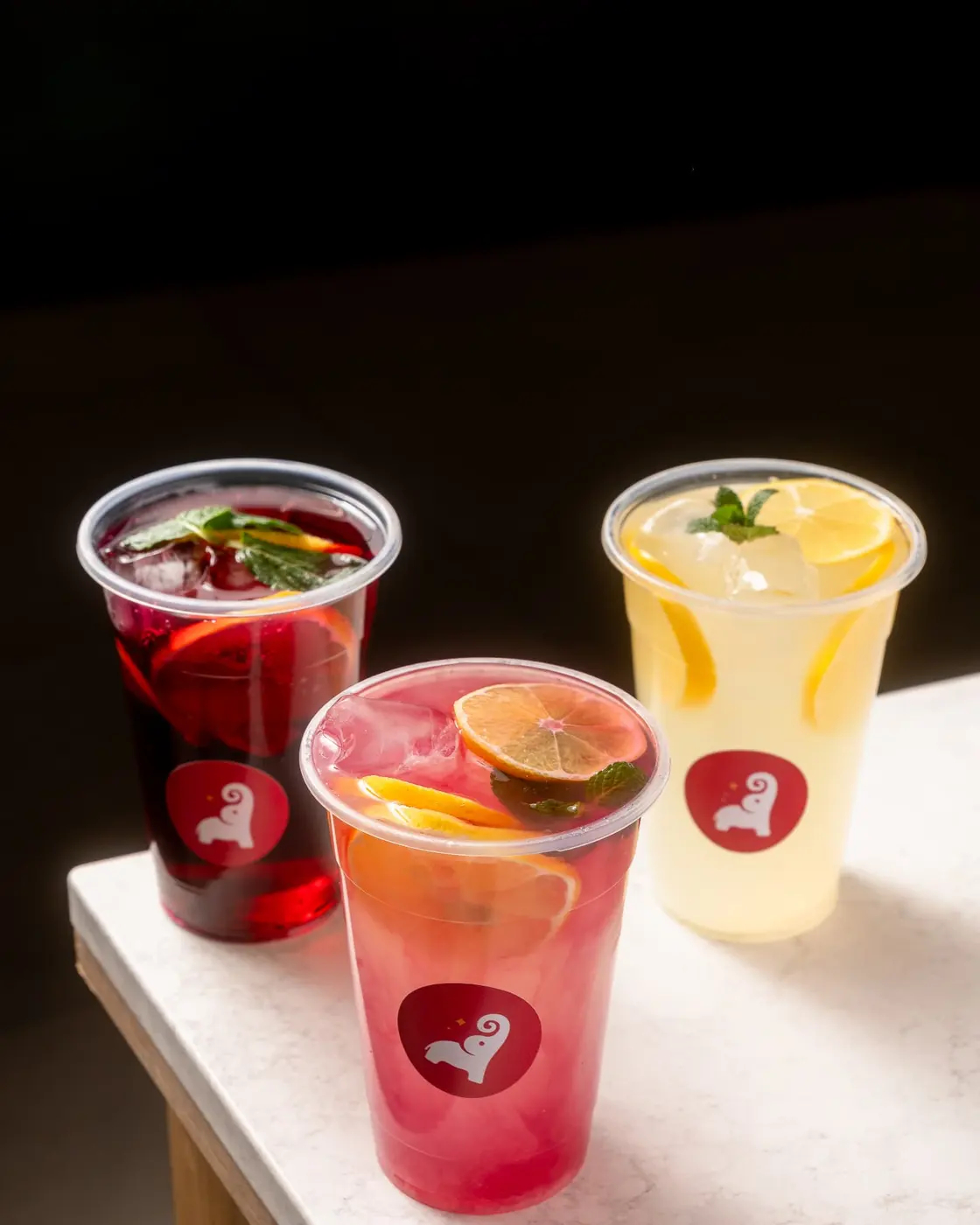 Three Tai Sweets fresh lemonades with fruit and mint in branded cups